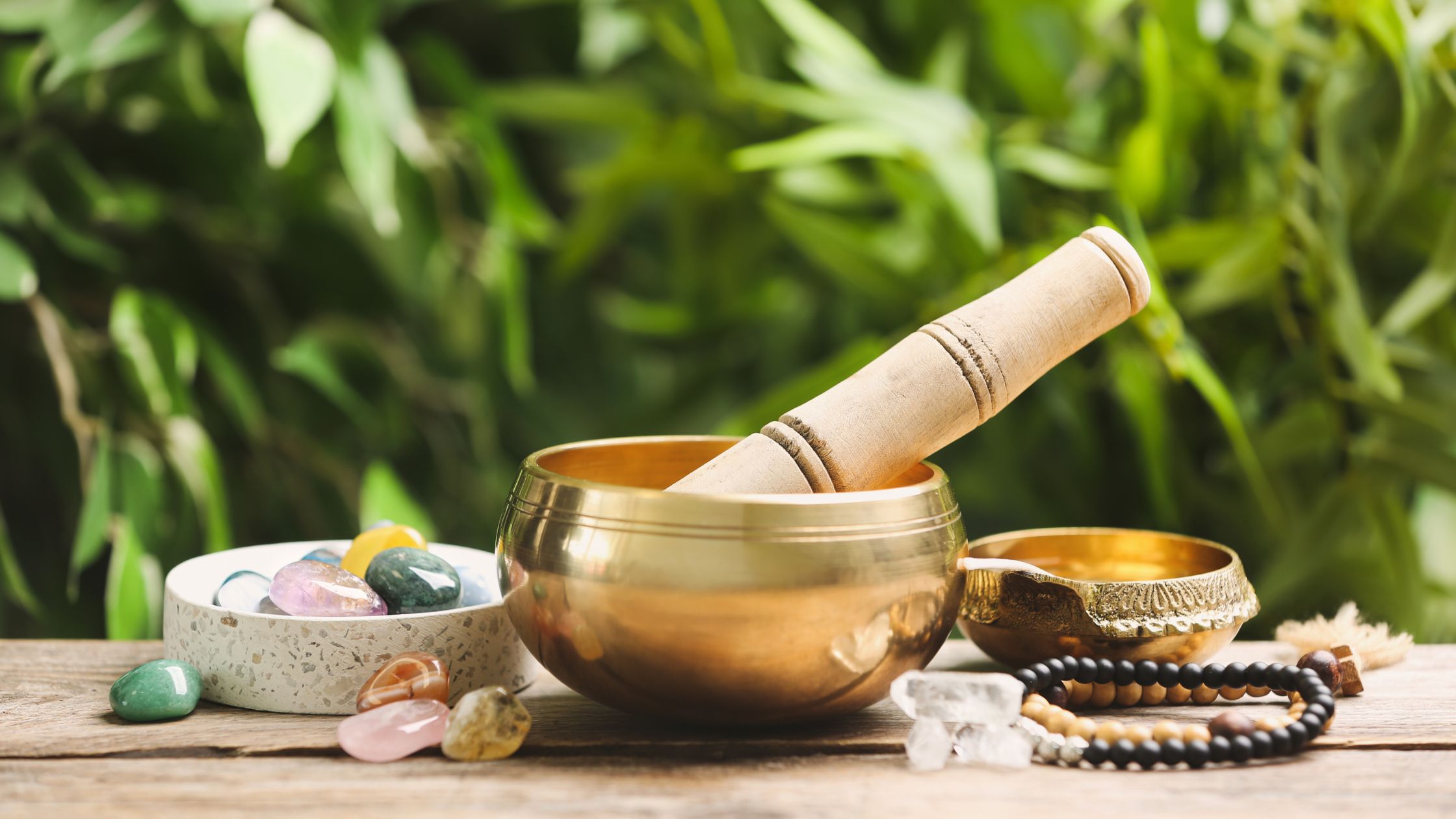 bronze singing bowl with mala beads and bamboo background